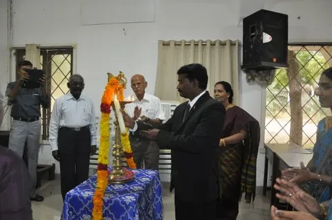 Guests lighting a ceremonial lamp at an indoor event