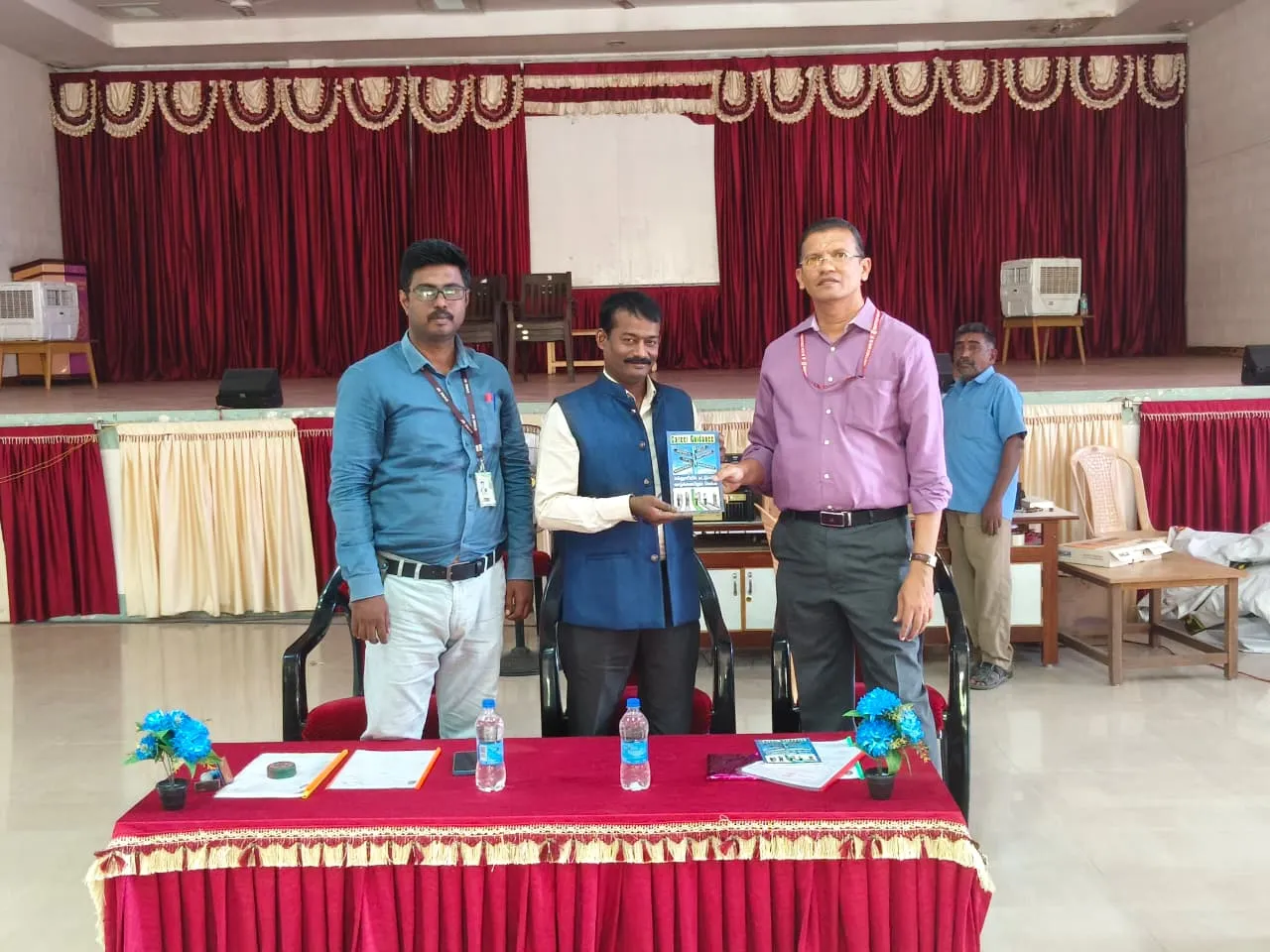 Memento being presented between representatives on a college stage