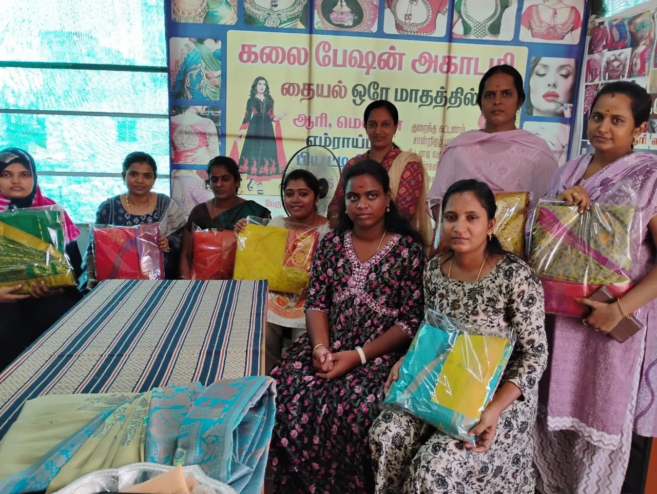 Women holding fabric material packets at a Kalai Fashion Academy session
