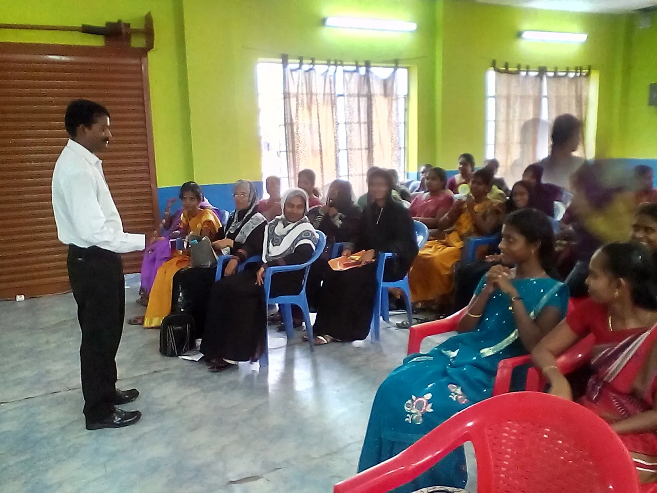 Parents seated on chairs listening to a speaker during an awareness session