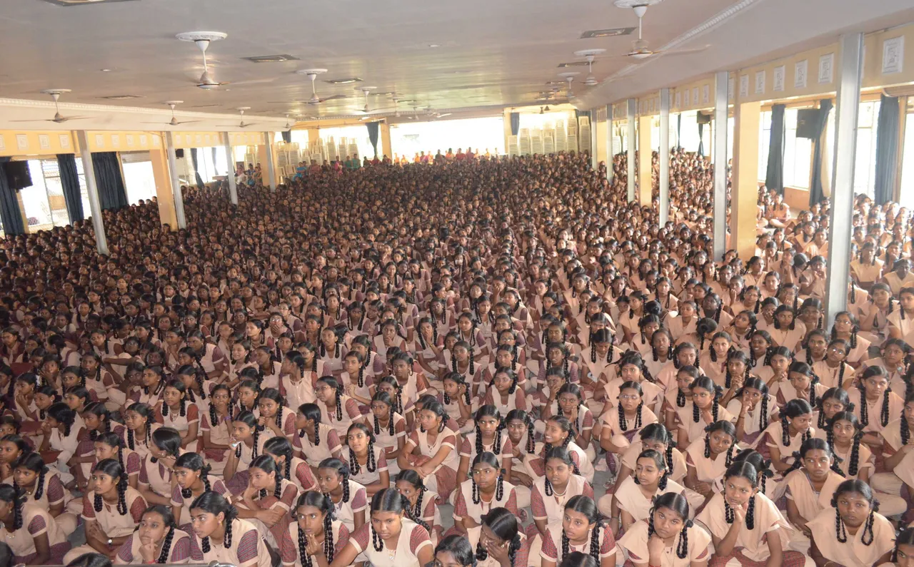 Large hall filled with school students seated for an assembly session