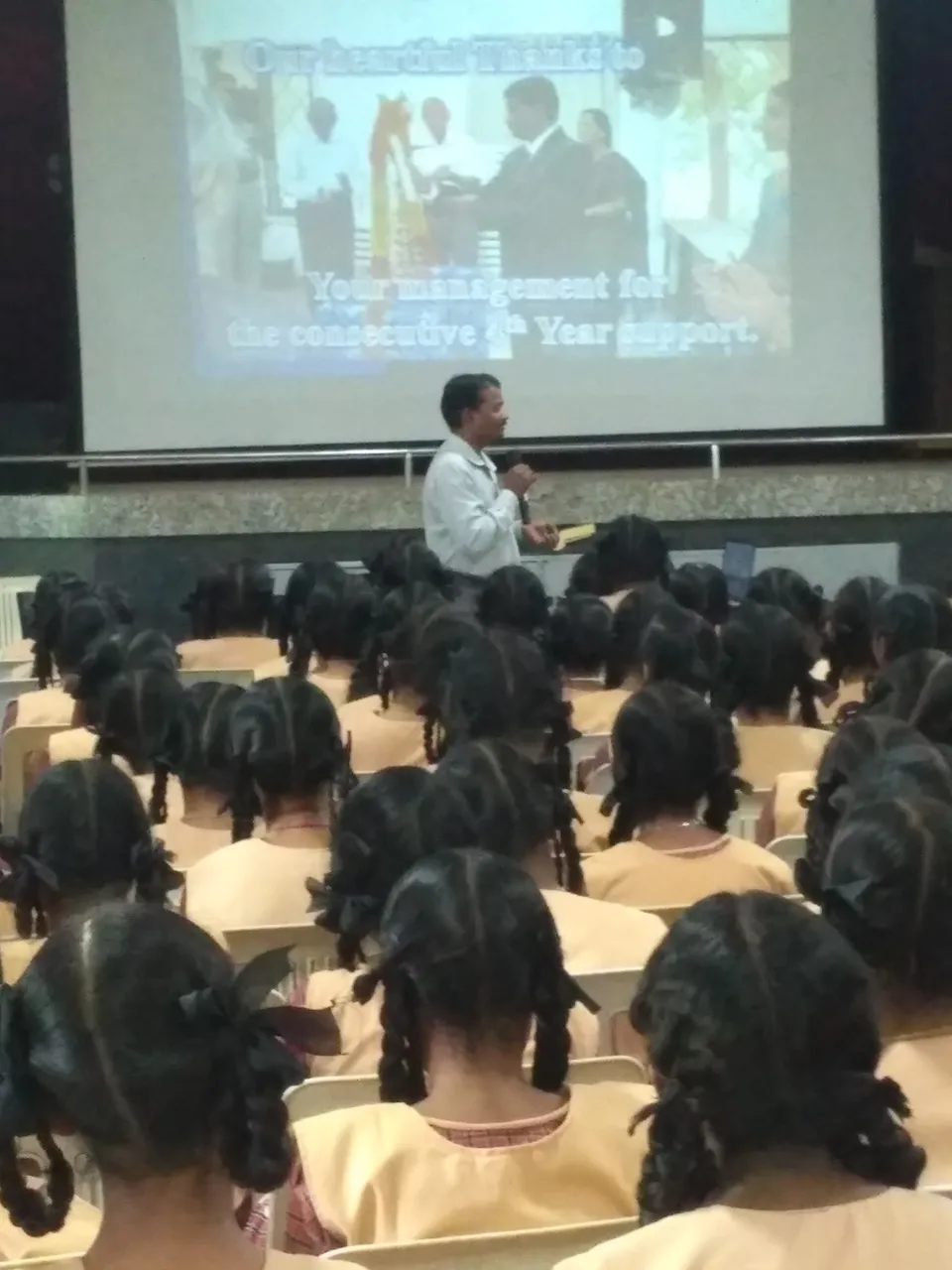 Students seated facing a presentation screen during a session